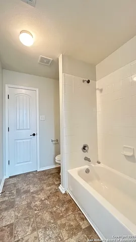 a white toilet sitting next to a bath tub