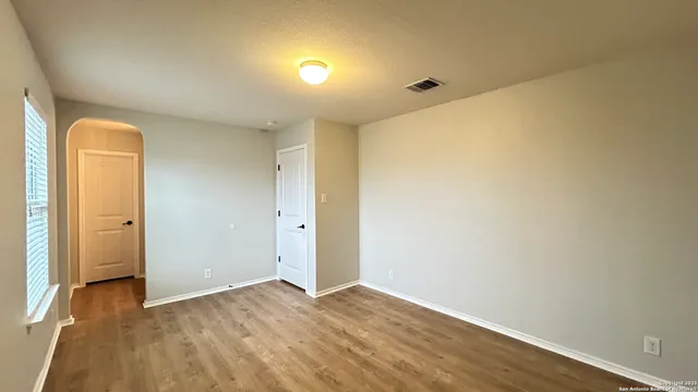 an empty room with windows and closet