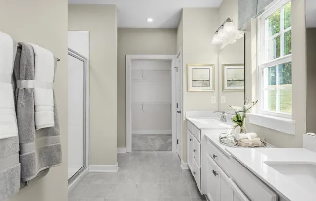 a bathroom with a double vanity sink a large mirror a shower and a bathtub