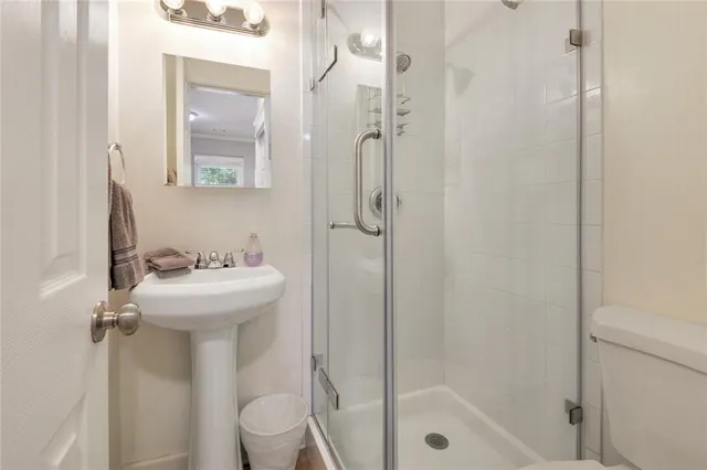 a bathroom with a sink a toilet and shower