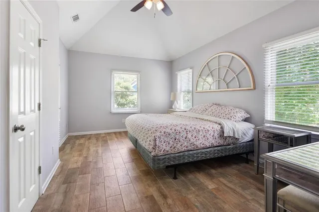 a bedroom with a large bed a chandelier and windows
