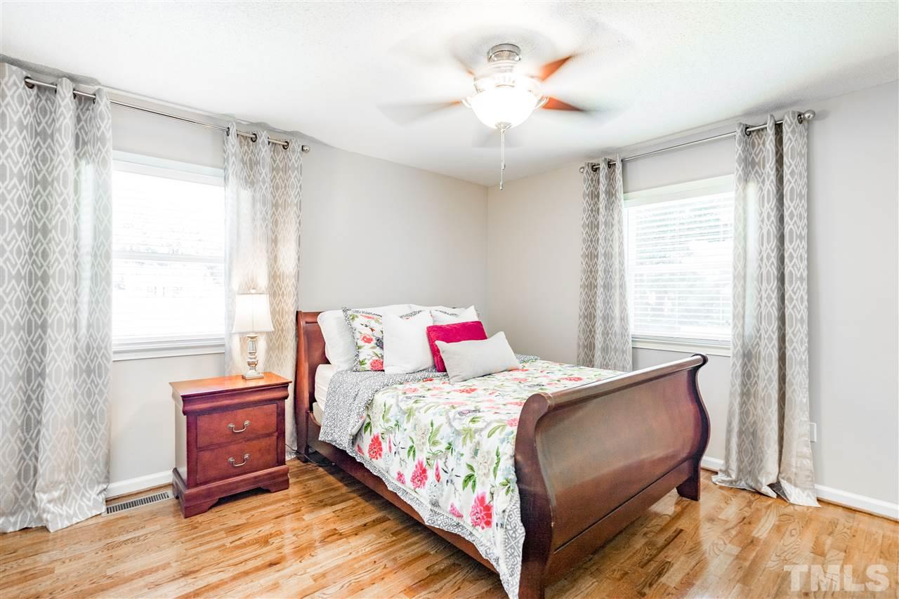 1005 Plateau Lane Raleigh, NC 27615 - Photo 11 of 29 a bedroom with a bed and a chandelier