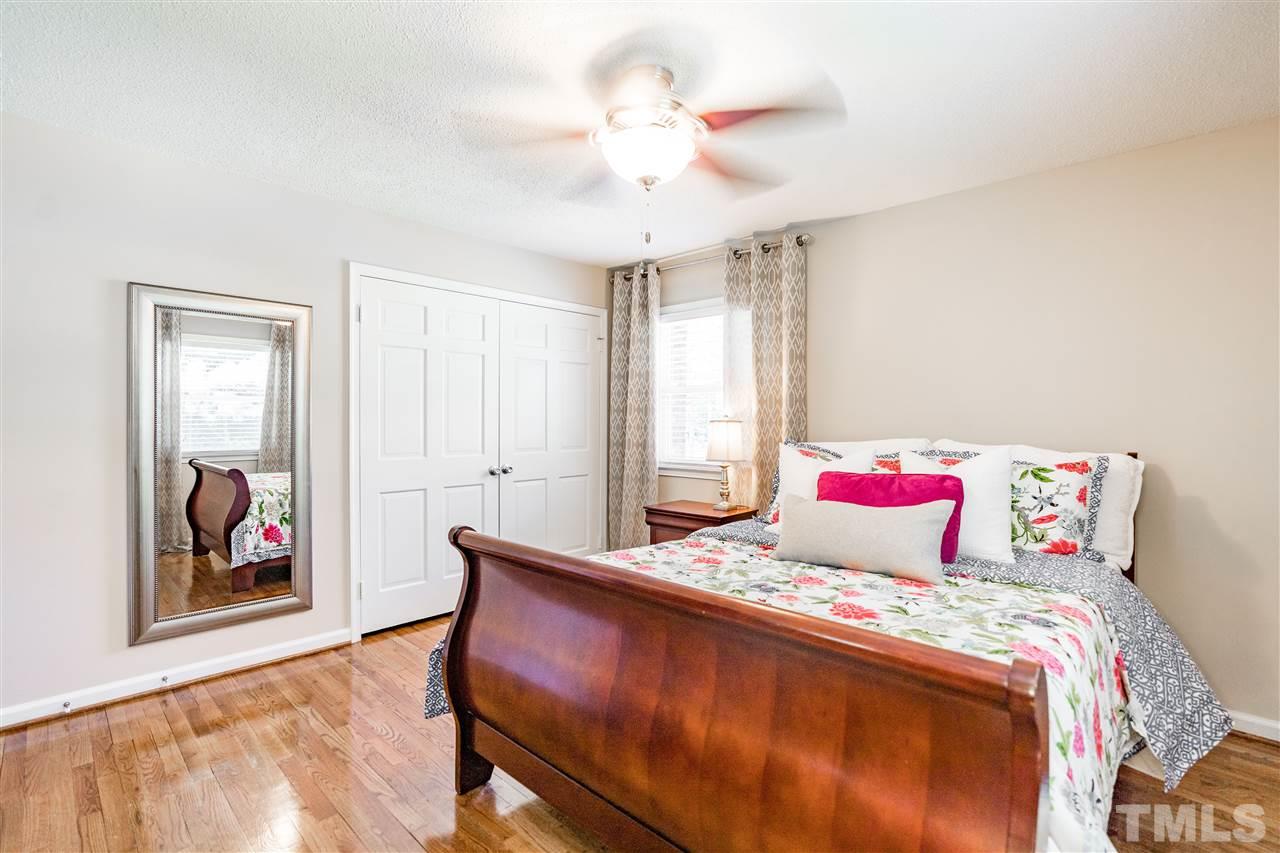 1005 Plateau Lane Raleigh, NC 27615 - Photo 12 of 29 a bedroom with a bed and a chandelier