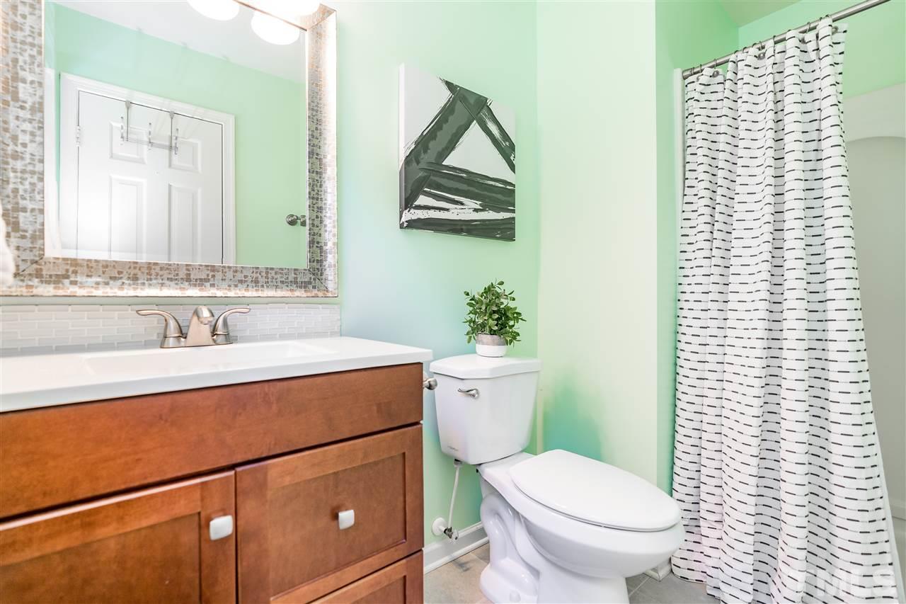 1005 Plateau Lane Raleigh, NC 27615 - Photo 13 of 29 a bathroom with a toilet sink and mirror