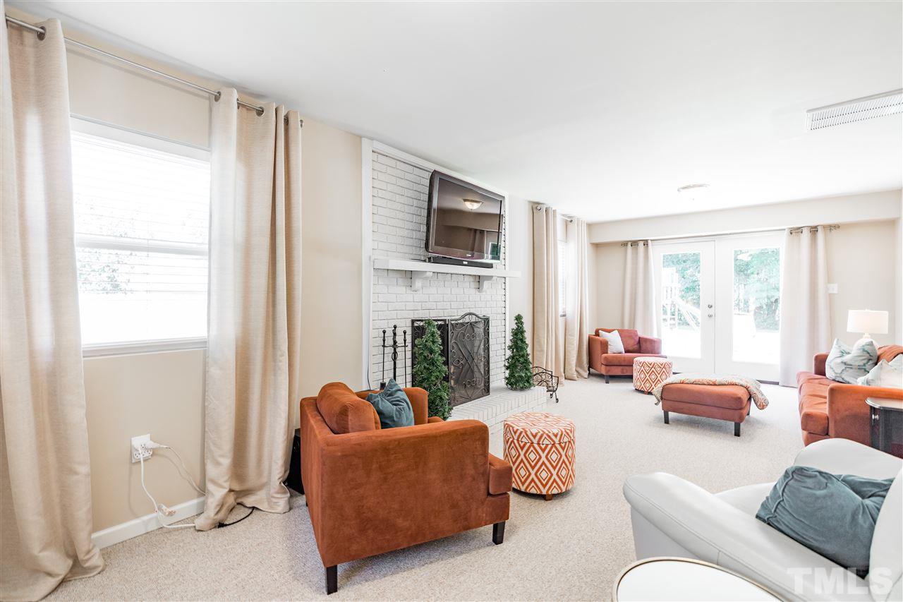 1005 Plateau Lane Raleigh, NC 27615 - Photo 17 of 29 a living room with furniture a fireplace and a window