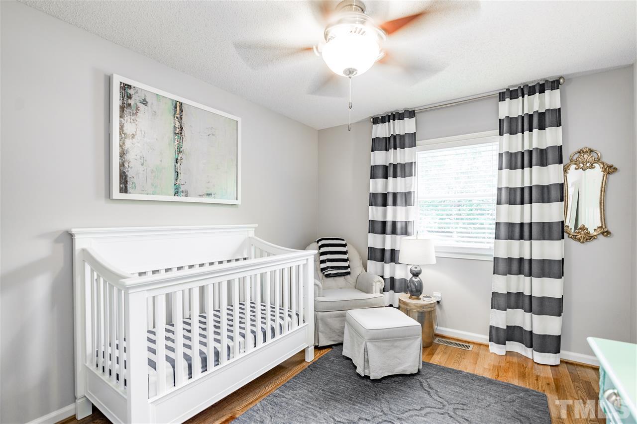1005 Plateau Lane Raleigh, NC 27615 - Photo 18 of 29 a bedroom with a white bed and a couch