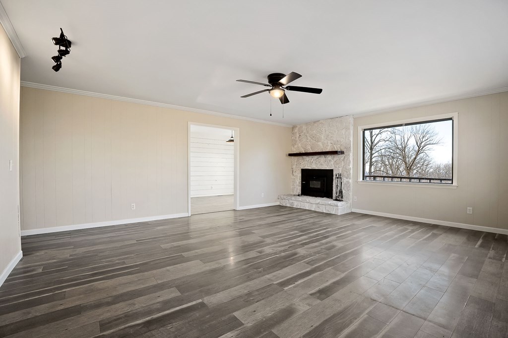 7927 Rocky Point Road Cookeville, TN 38506 - Photo 4 of 26 a view of empty room with wooden floor and fireplace