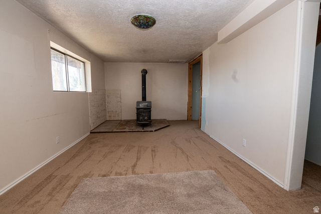 570 West Main Street Beaver, UT 84713 - Photo 22 of 43 Living area featuring a wood-burning stove with a tile hearth and a window providing natural light