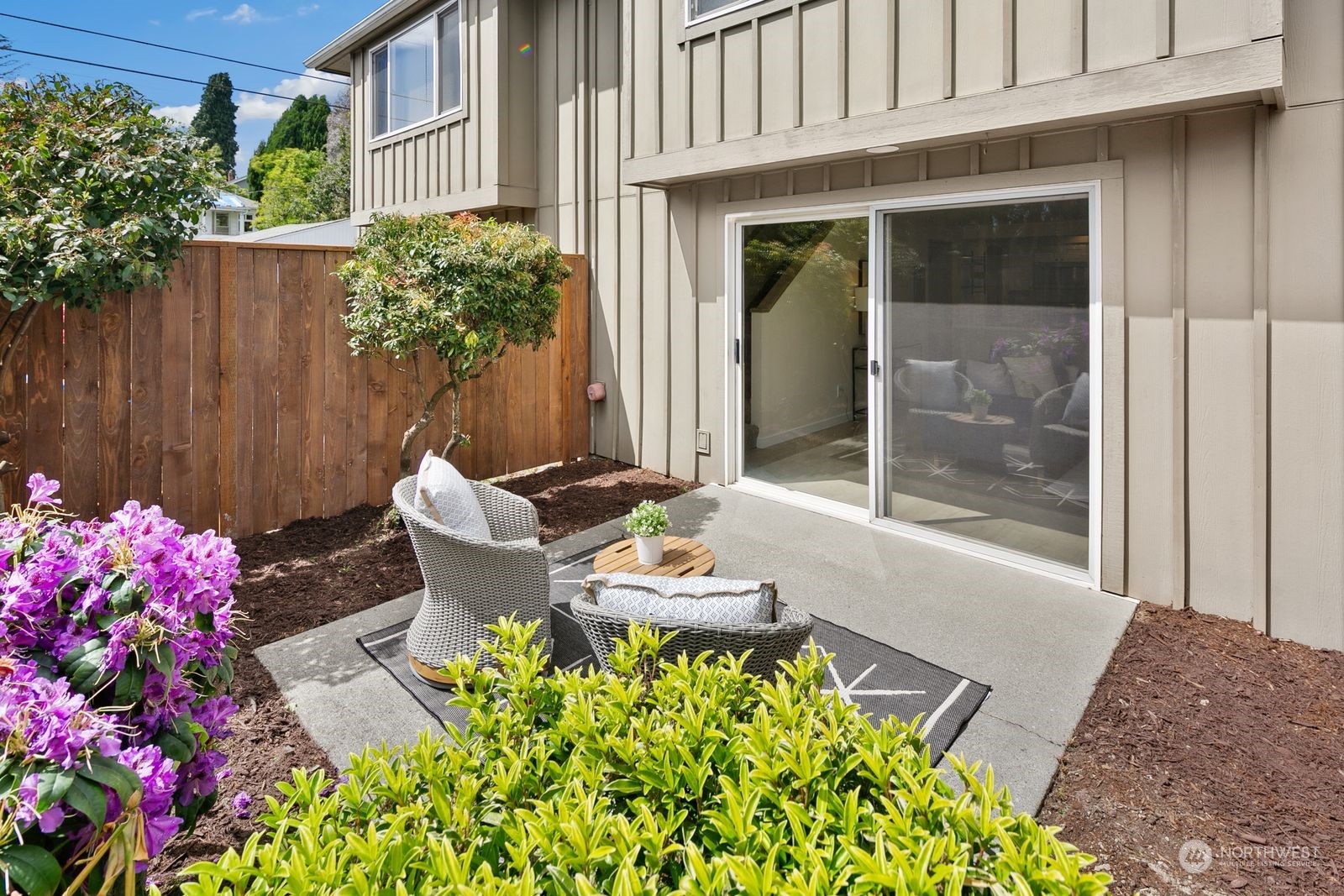 5421 Fauntleroy Way Southwest, Unit A Seattle, WA 98136 - Photo 17 of 18 a patio with table and chairs and potted plants