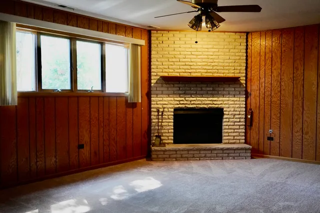 a view of an empty room with a fireplace and a window