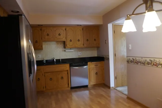 a kitchen with stainless steel appliances granite countertop a refrigerator a sink and a stove