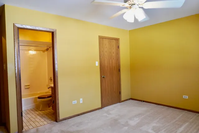 an empty room with a mirror and a fan