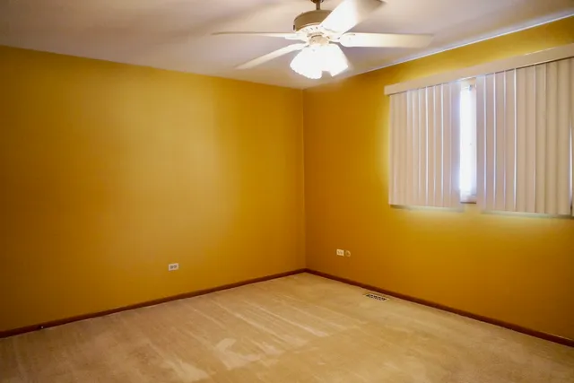 a view of a big room with windows and chandelier fan
