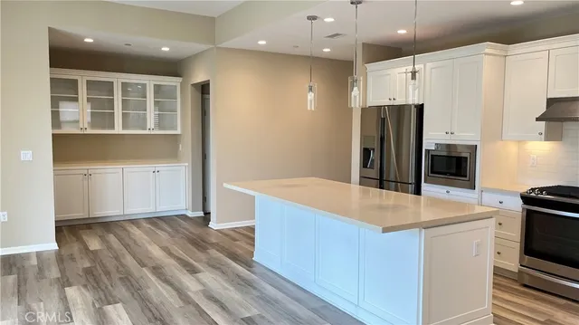 a kitchen with kitchen island a counter top space appliances and cabinets