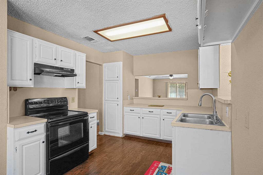 2134 Reverchon Drive Arlington, TX 76017 - Photo 6 of 23 Kitchen has apple suppy of cabinets, electric freestanding stove. A opening to stay engarged while cooking a meal.