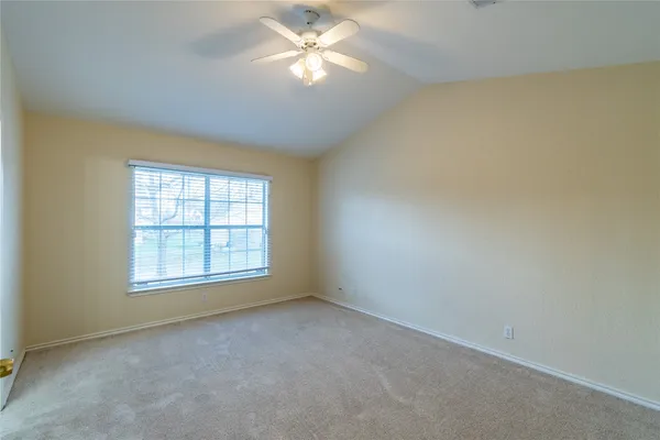 an empty room with a window and a fan