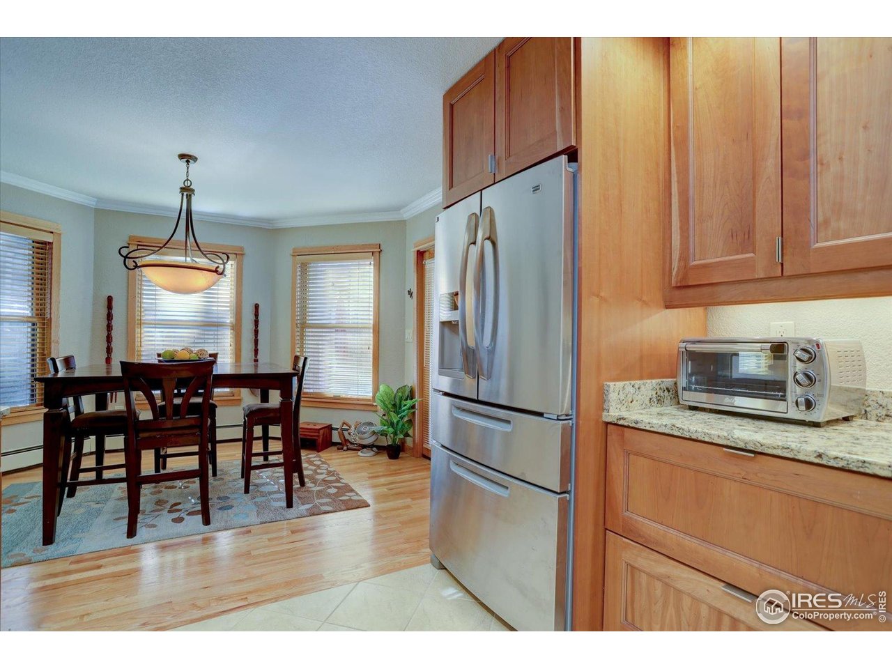 815 16th Street Boulder, CO 80302 - Photo 11 of 47 a kitchen with stainless steel appliances granite countertop a refrigerator a stove a dining table and chairs