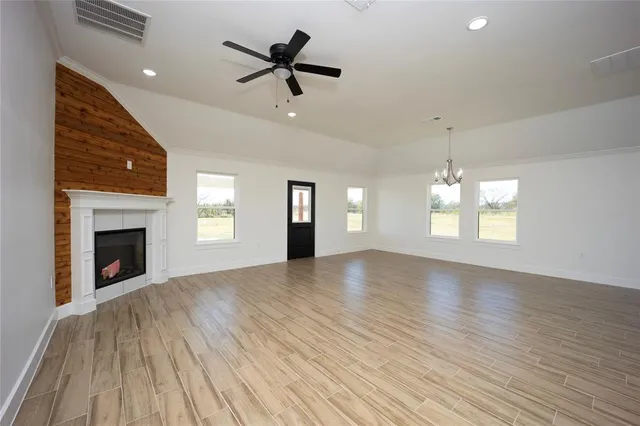 an empty room with windows and fireplace