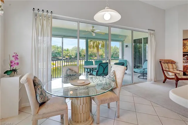 a dining room with furniture a chandelier and glass door