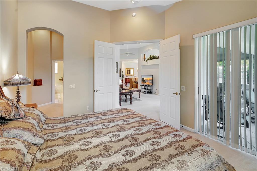 23156 Rosedale Drive, Unit 201 Estero, FL 34135 - Photo 20 of 50 a bedroom with a bed and a large mirror