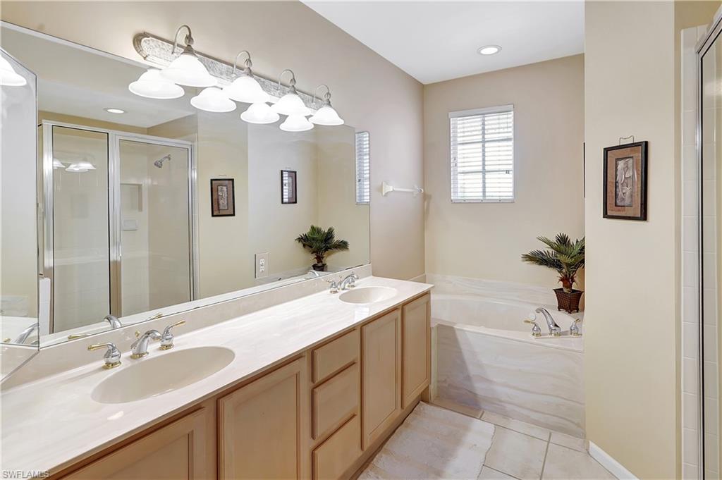 23156 Rosedale Drive, Unit 201 Estero, FL 34135 - Photo 21 of 50 a bathroom with a tub sink and mirror