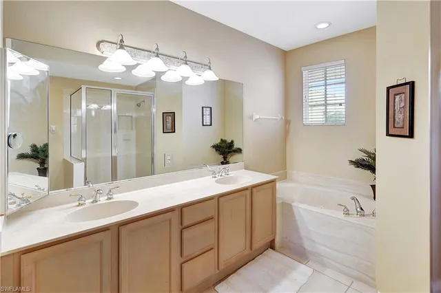 a bathroom with a sink double vanity granite tub and a mirror