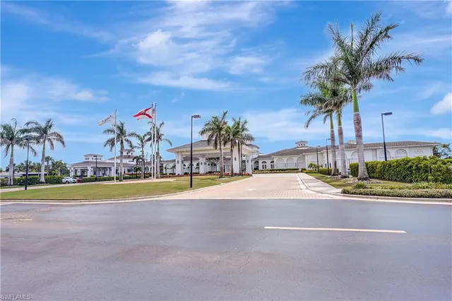 a view of a swimming pool with a yard and palm trees