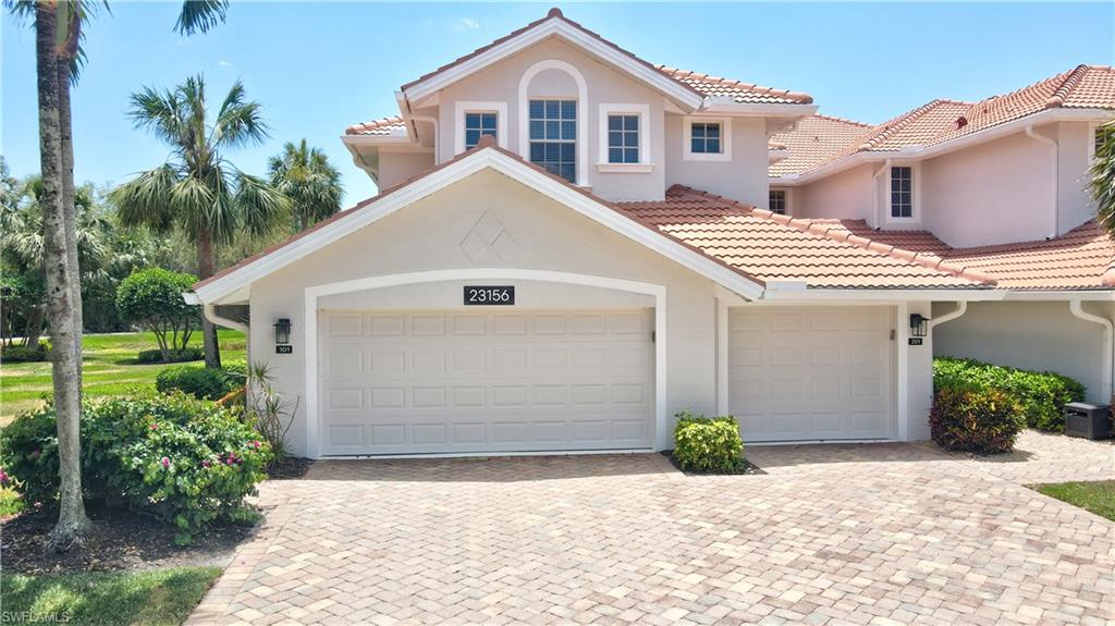 23156 Rosedale Drive, Unit 201 Estero, FL 34135 - Photo 48 of 50 a view of a white house with a yard and plants