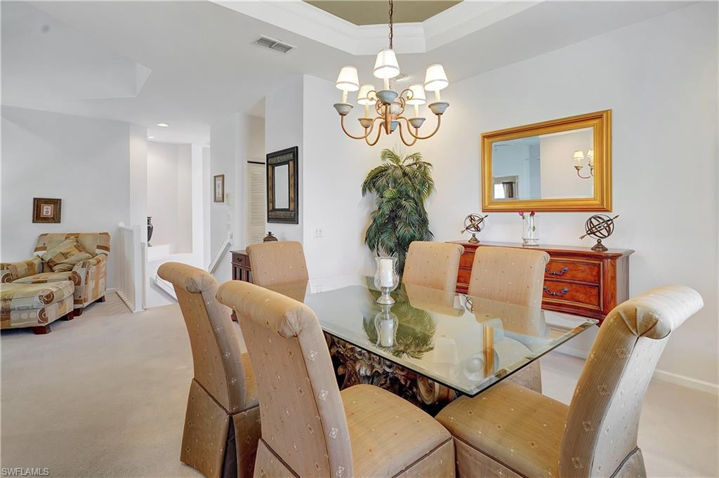 23156 Rosedale Drive, Unit 201 Estero, FL 34135 - Photo 6 of 50 a view of a dining room with furniture a chandelier and wooden floor