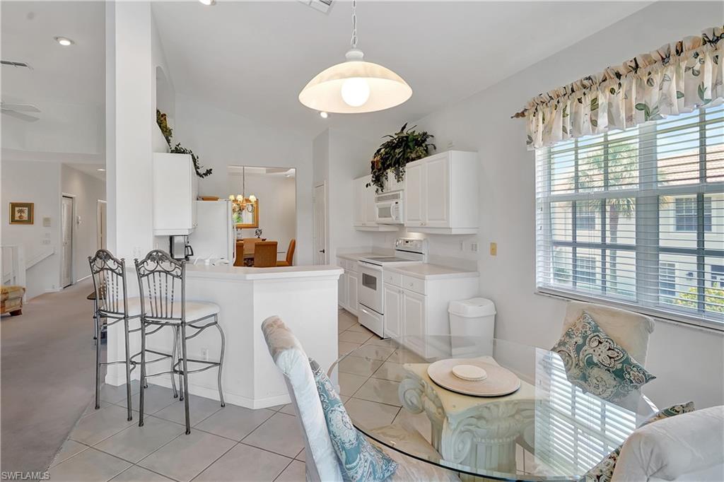 23156 Rosedale Drive, Unit 201 Estero, FL 34135 - Photo 10 of 50 a living room with furniture and a dining table with kitchen appliances