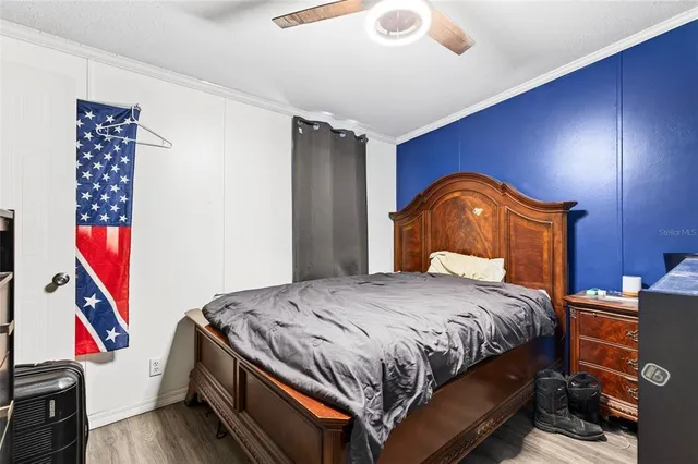 a bedroom with bed and wooden floor