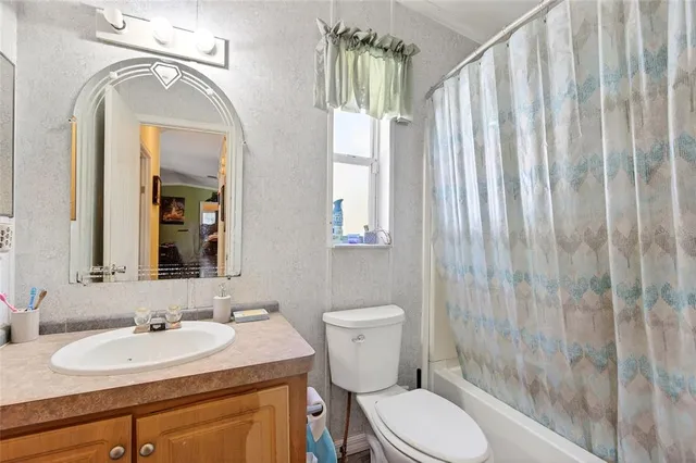 a bathroom with a granite countertop sink toilet and mirror