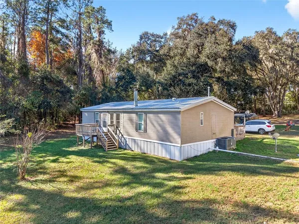 a view of a house with a yard and sitting area