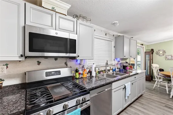 a kitchen with stainless steel appliances kitchen island granite countertop a sink and a stove