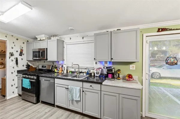 a kitchen with stainless steel appliances granite countertop a sink stove and refrigerator