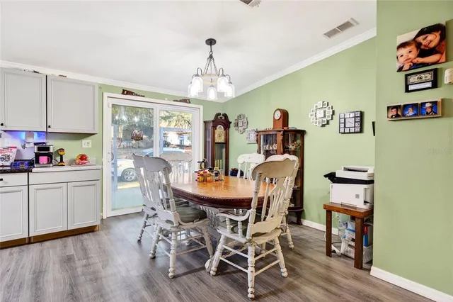 a dining room with furniture a chandelier and wooden floor