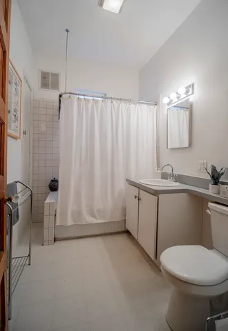 a white toilet sitting next to a bathroom sink and tub