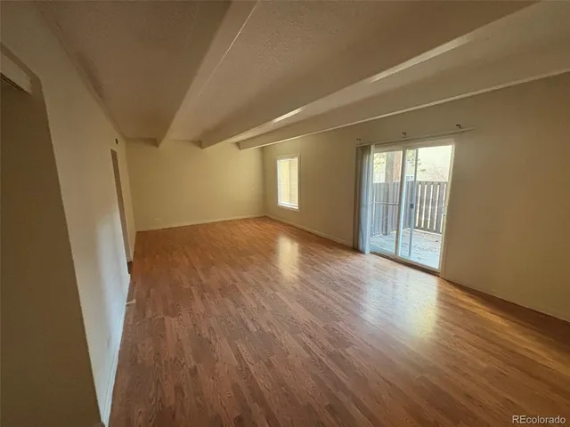 a kitchen with granite countertop a sink a stove top oven and cabinetry