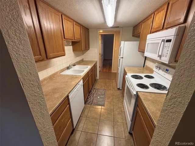 a view of a kitchen with wooden floor and a sink