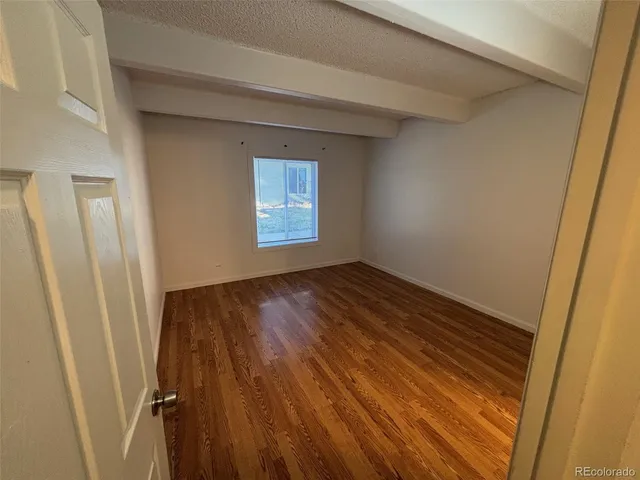 an empty room with wooden floor and closet