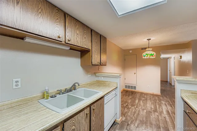 a kitchen with granite countertop a sink cabinets and wooden floor