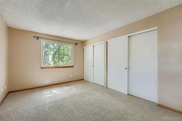an empty room with windows and closet