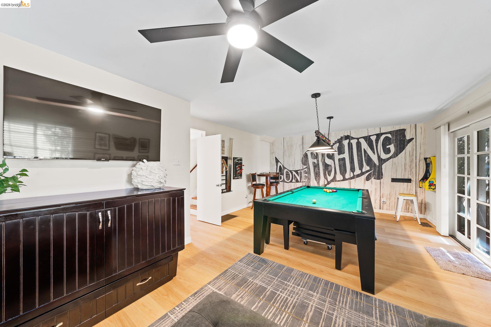 1704 Taylor Road Bethel Island, CA 94511 - Photo 10 of 73 Recreation space featuring wood-finish flooring, a ceiling fan with integrated lighting, a wall-mounted display, and white French doors