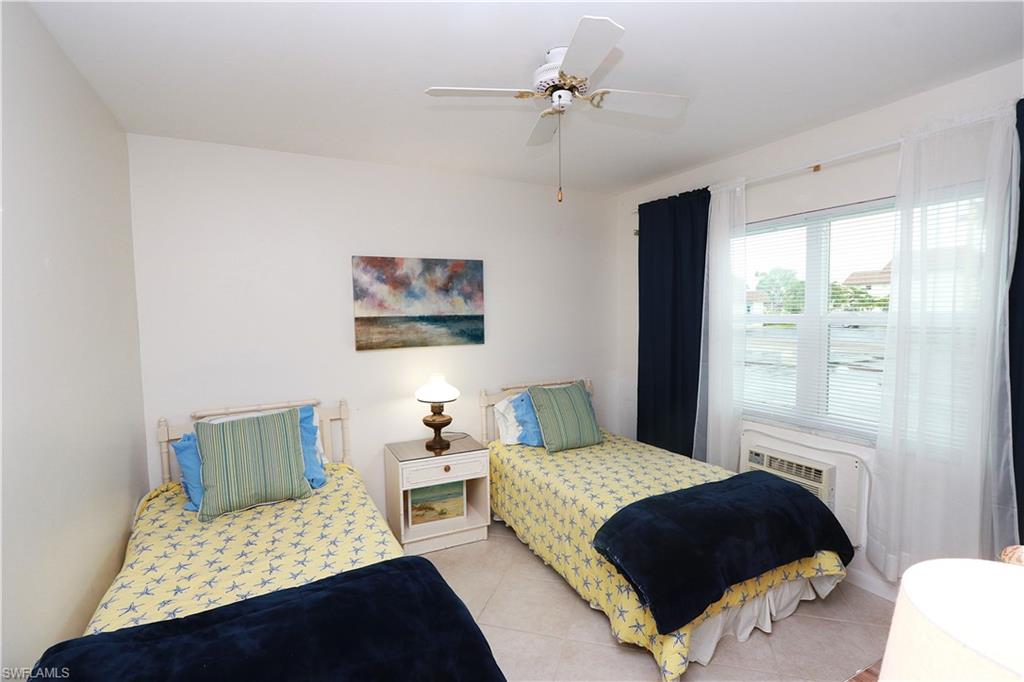 235 Seaview Court, Unit B5 Marco Island, FL 34145 - Photo 12 of 23 a bedroom with a bed lamp and a window
