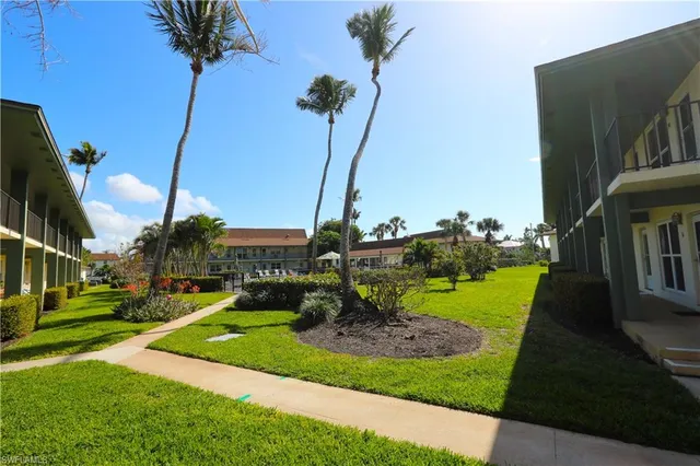 a view of a house with a yard and potted plants