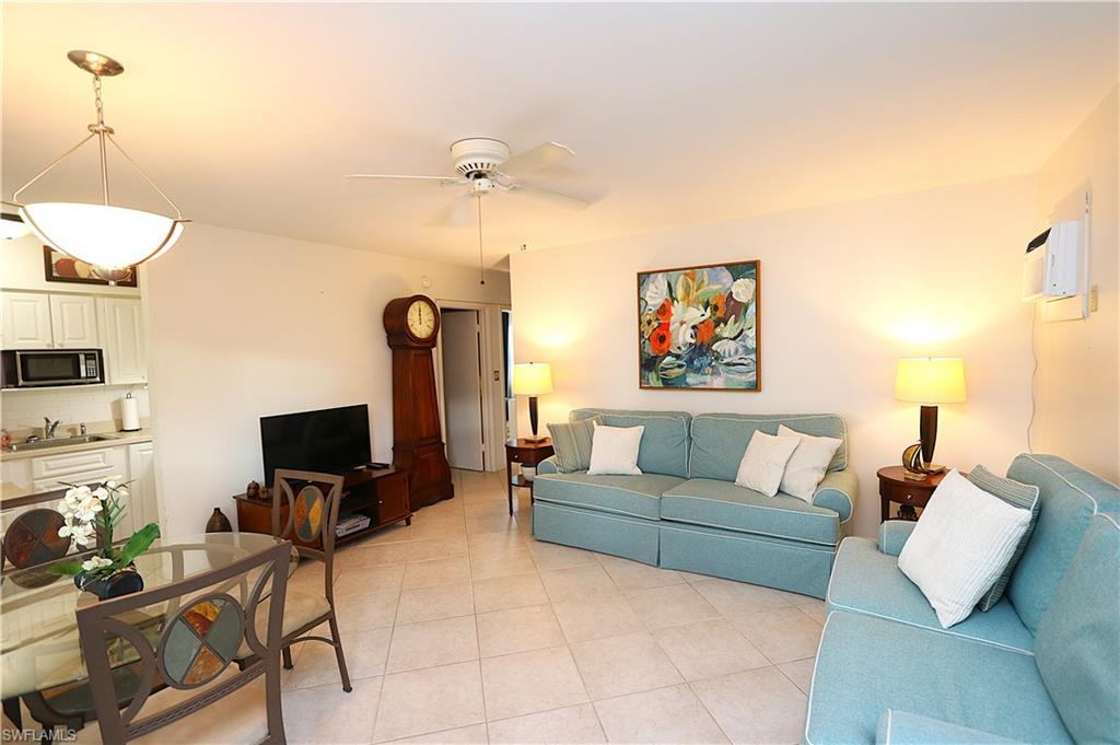 235 Seaview Court, Unit B5 Marco Island, FL 34145 - Photo 3 of 23 a living room with furniture a flat screen tv and a fireplace