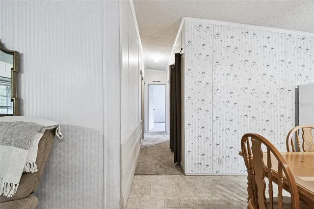 an empty room with a chandelier fan and windows