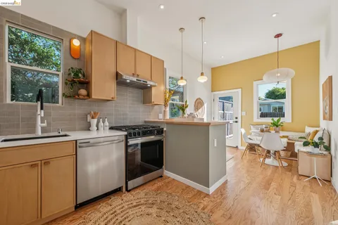 a kitchen with stainless steel appliances granite countertop a sink a stove and a wooden floors