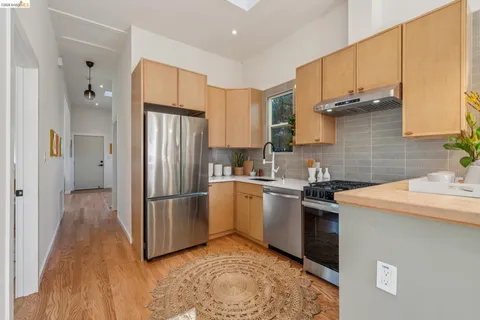 a kitchen with stainless steel appliances granite countertop a refrigerator sink and wooden cabinets