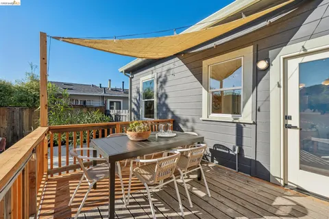 a view of a patio with table and chairs with wooden floor and fence